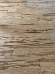 Smooth hardwood flooring being installed with natural light highlighting the grain.
