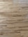 Wooden floor with a natural grain pattern and a light brown color. The surface appears smooth with slightly visible seams between the planks, giving it a polished look.