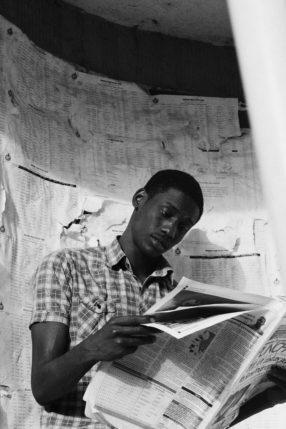 man in plaid shirt reading book