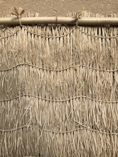 Artisan hands weaving bamboo strips to create traditional bahareque walls.