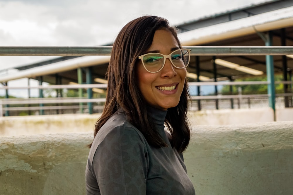 woman in gray jacket wearing red framed eyeglasses