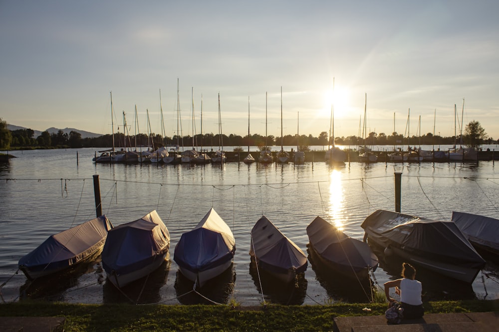 Barcos en el agua cerca del muelle durante la puesta de sol