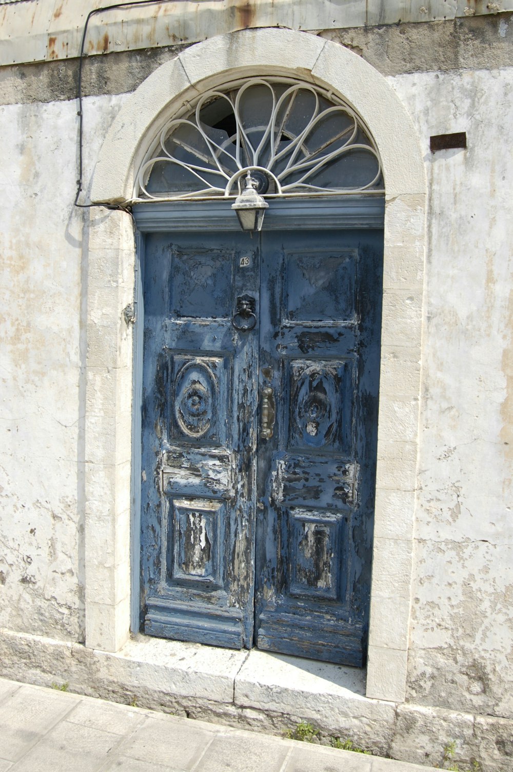 blue wooden door on white concrete wall