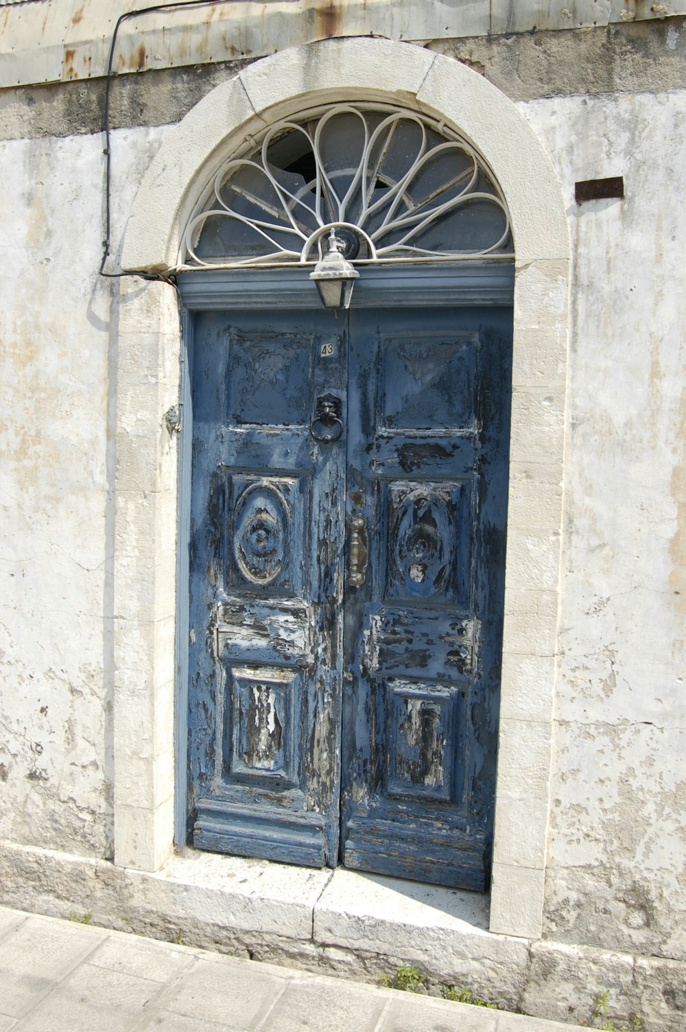 blaue Holztür an weißer Betonwand