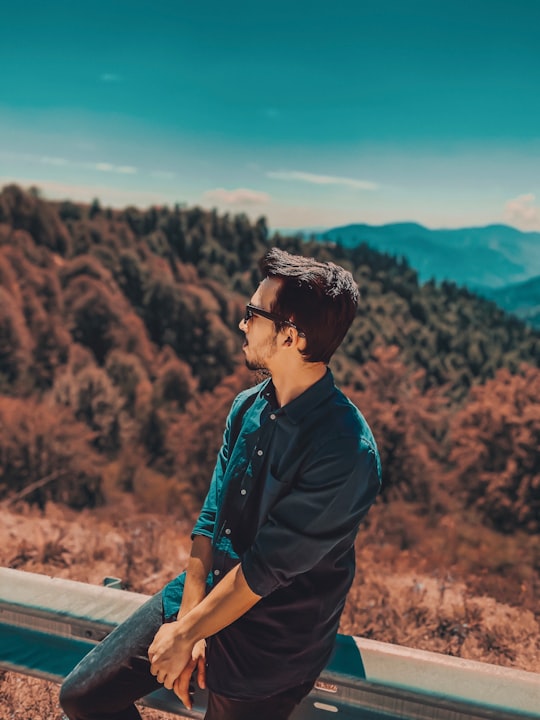 man in black jacket and brown pants standing on gray concrete fence during daytime in Bolu Turkey