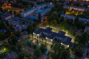 Evening shot of a finished residential complex illuminated with warm lights.