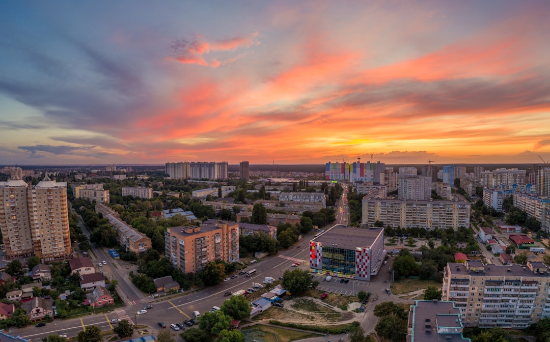 city with high rise buildings under orange and gray skies