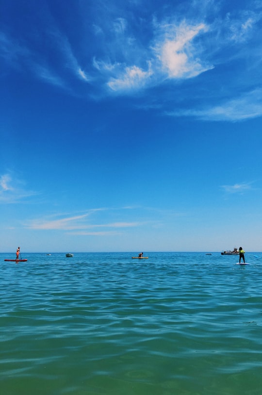 people in sea under blue sky during daytime in Burgau Portugal