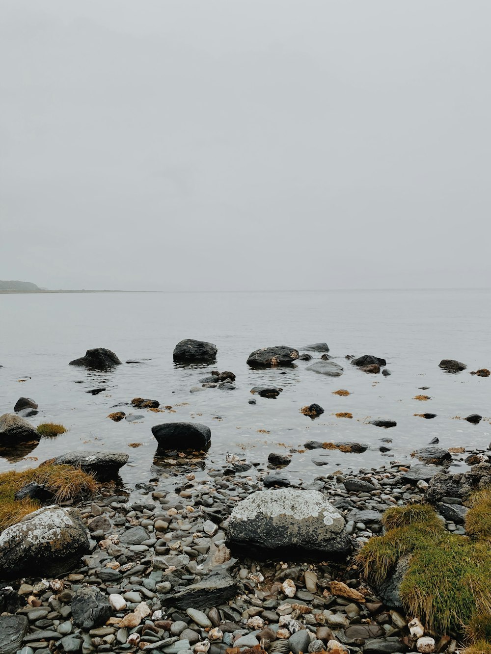 gray rocks on body of water during daytime