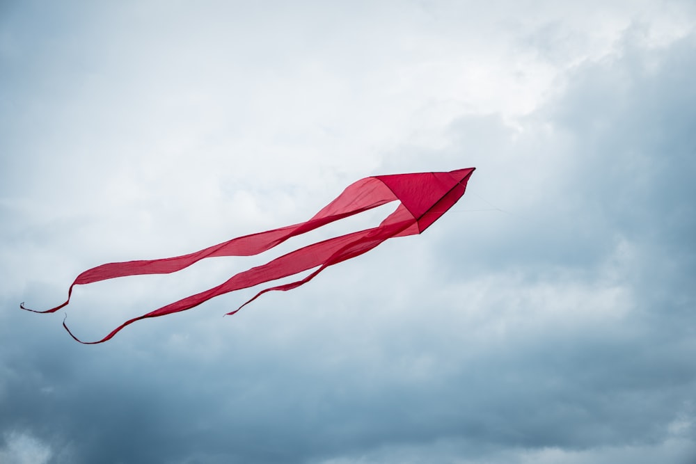 Bandera roja en el mástil bajo el cielo nublado