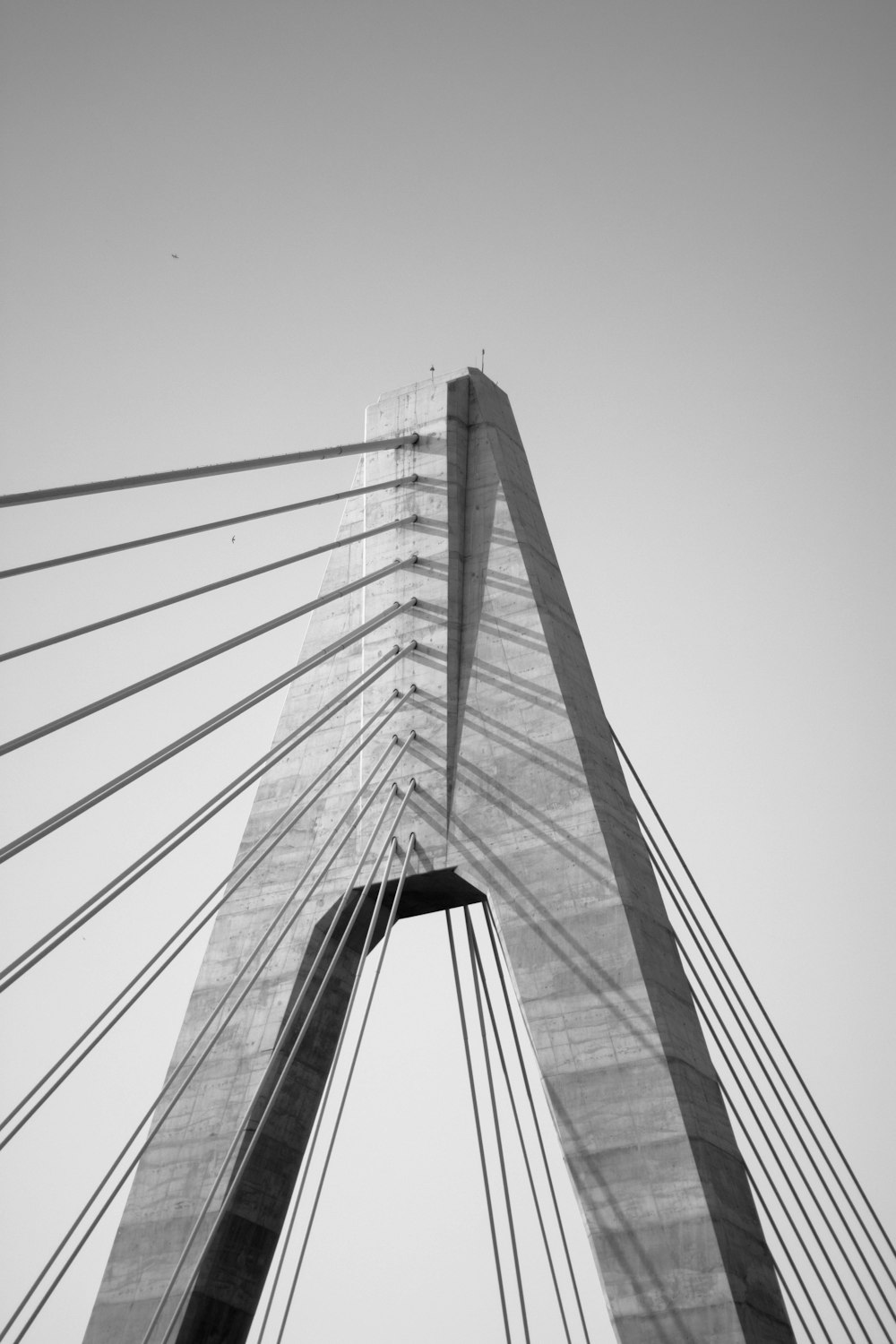 foto em tons de cinza da ponte sob o céu nublado