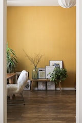Vibrant mustard yellow accent wall bringing warmth to a cozy reading nook.
