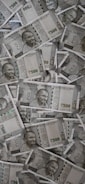 A large pile of Indian currency notes, featuring the portrait of Mahatma Gandhi. The notes are primarily 500 denomination, arranged in a slightly disordered manner.
