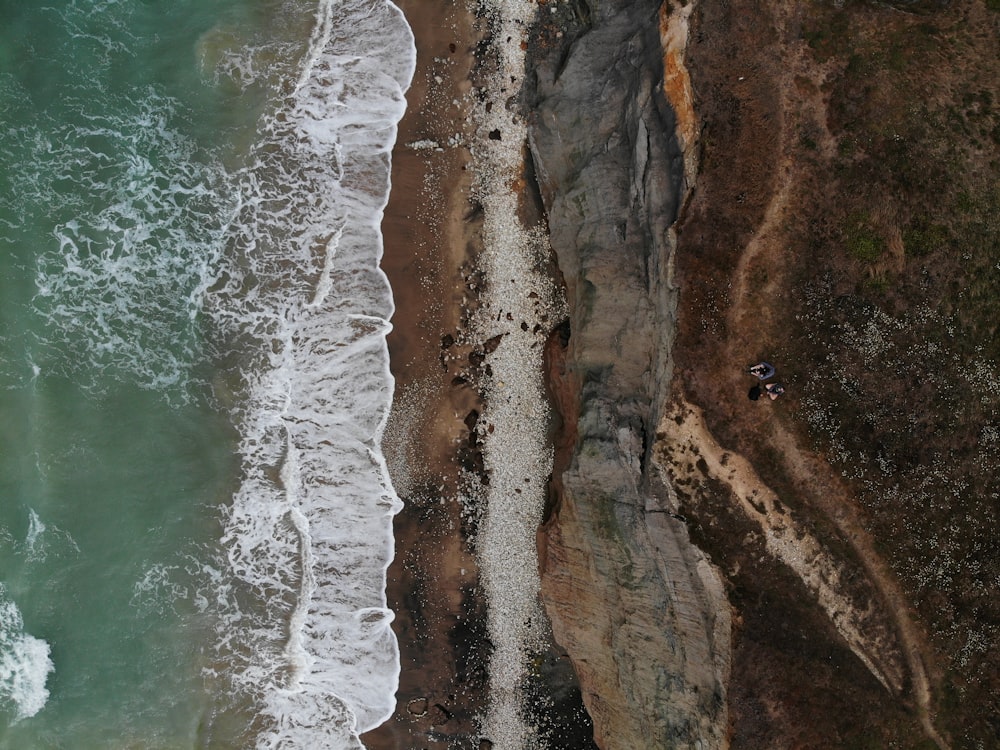 brown rocky mountain beside body of water during daytime