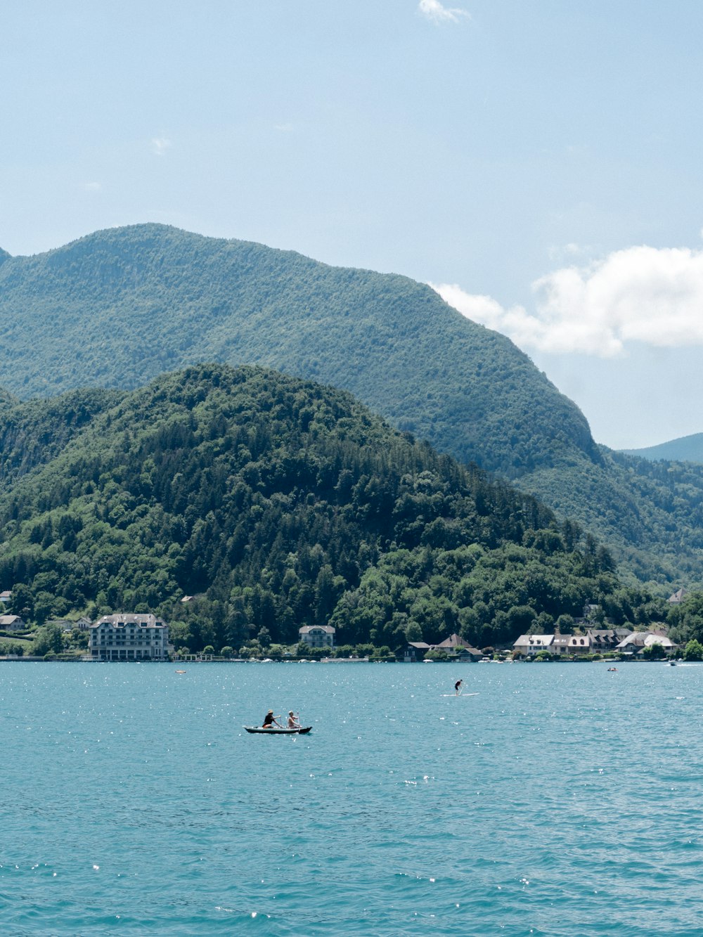 people riding on boat on sea near mountain during daytime