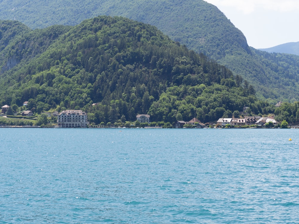 green mountain beside body of water during daytime