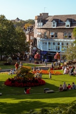 people sitting on green grass field near brown concrete building during daytime