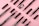 Several makeup brushes and eyebrow pencils are neatly arranged on a pink background. The items are in various states of assembly, with some showing bristles and others revealing the pencil tips.