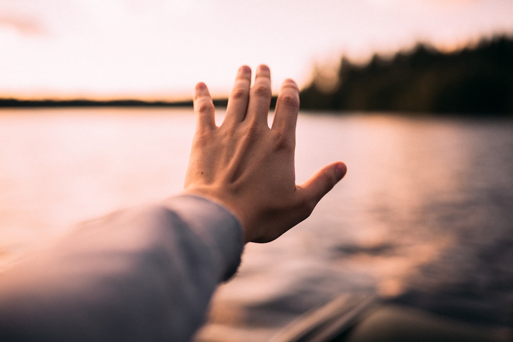 Person im grauen Langarmhemd mit linker Hand