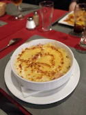 Steaming bowl of creamy mac and cheese topped with crispy breadcrumbs.