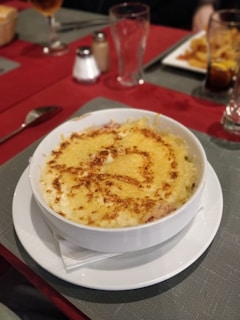 A colorful bowl of creamy mac and cheese topped with crispy breadcrumbs.