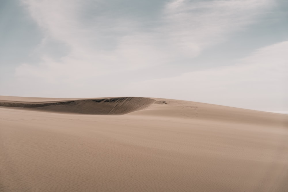 sabbia marrone sotto cielo blu durante il giorno