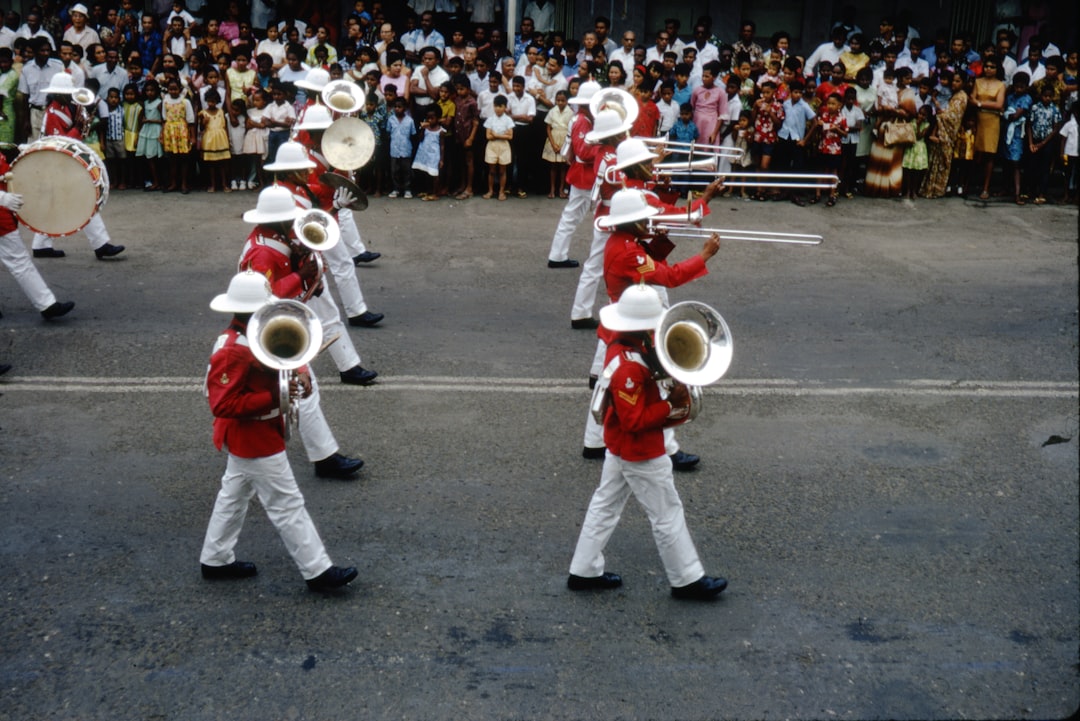 people in white uniform playing musical instruments on street during daytime