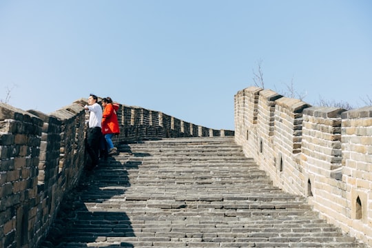 man in red jacket walking on concrete stairs in Beijing China