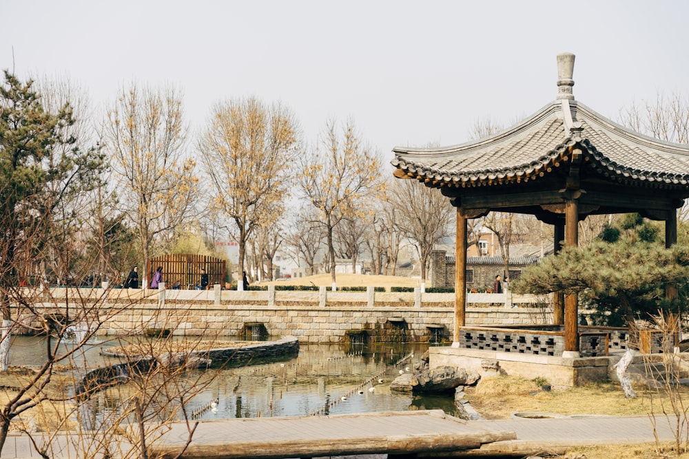 brown wooden gazebo near body of water during daytime