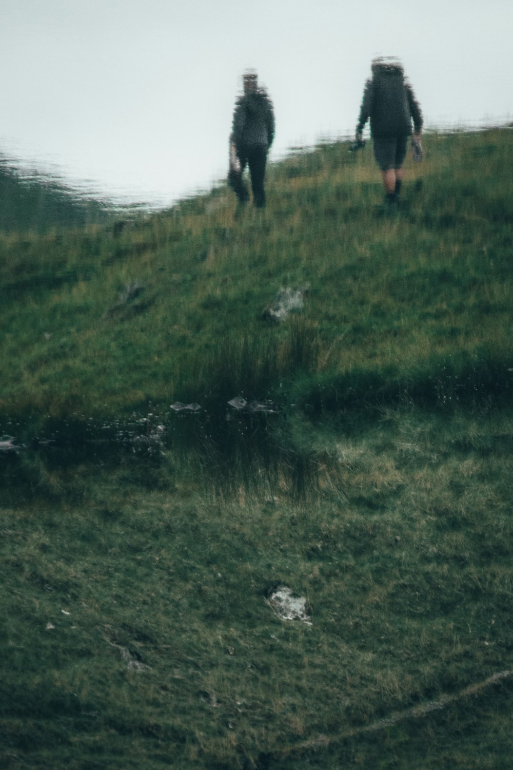 person in black pants standing on green grass field during daytime