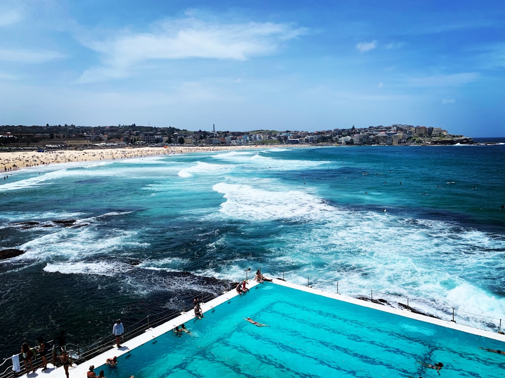 people swimming on pool near beach during daytime