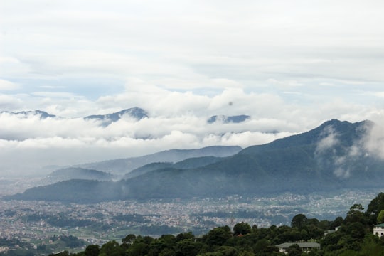green trees and mountains under white clouds during daytime in Kathmandu Nepal