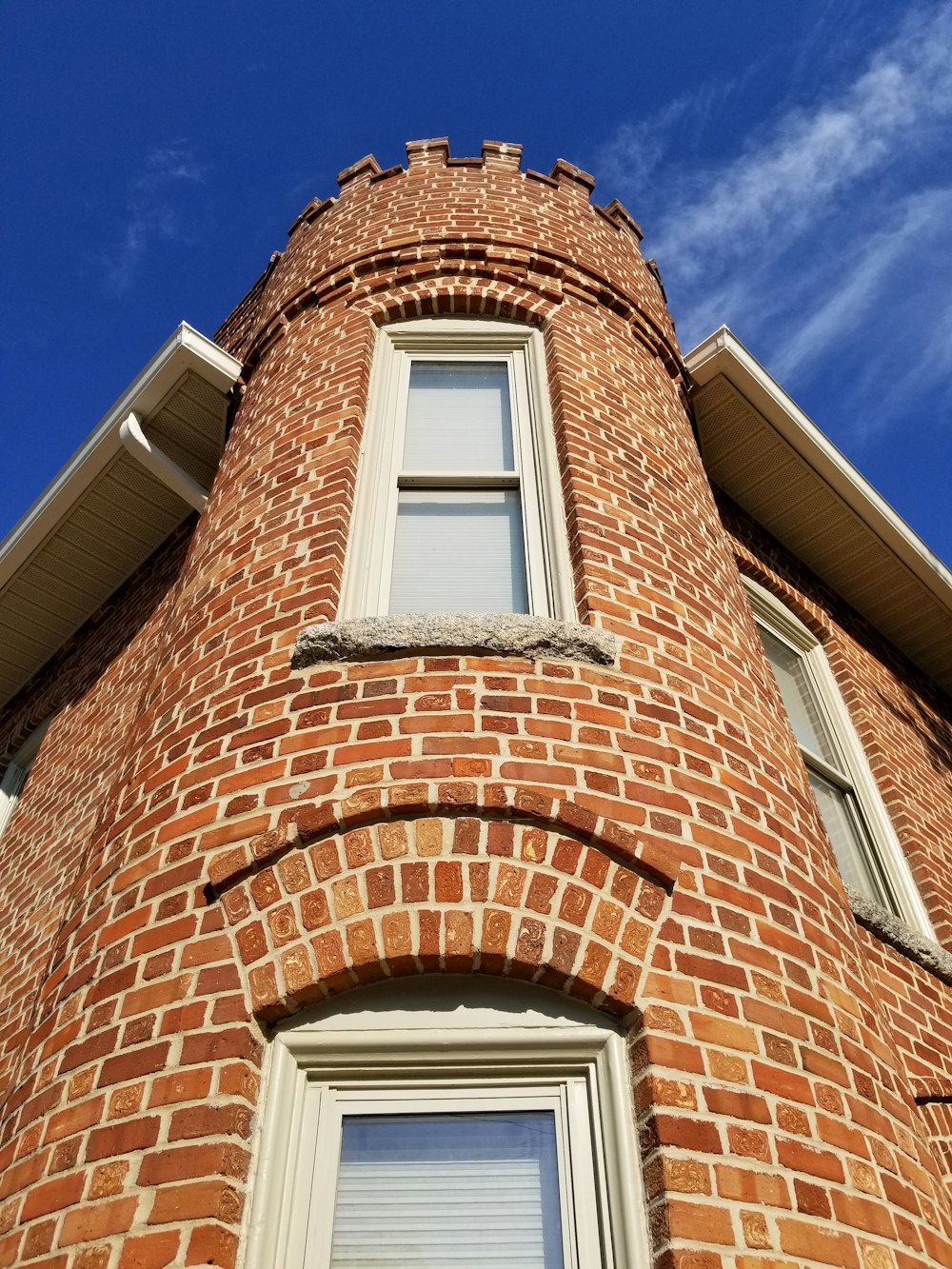 brown brick building with white wooden window