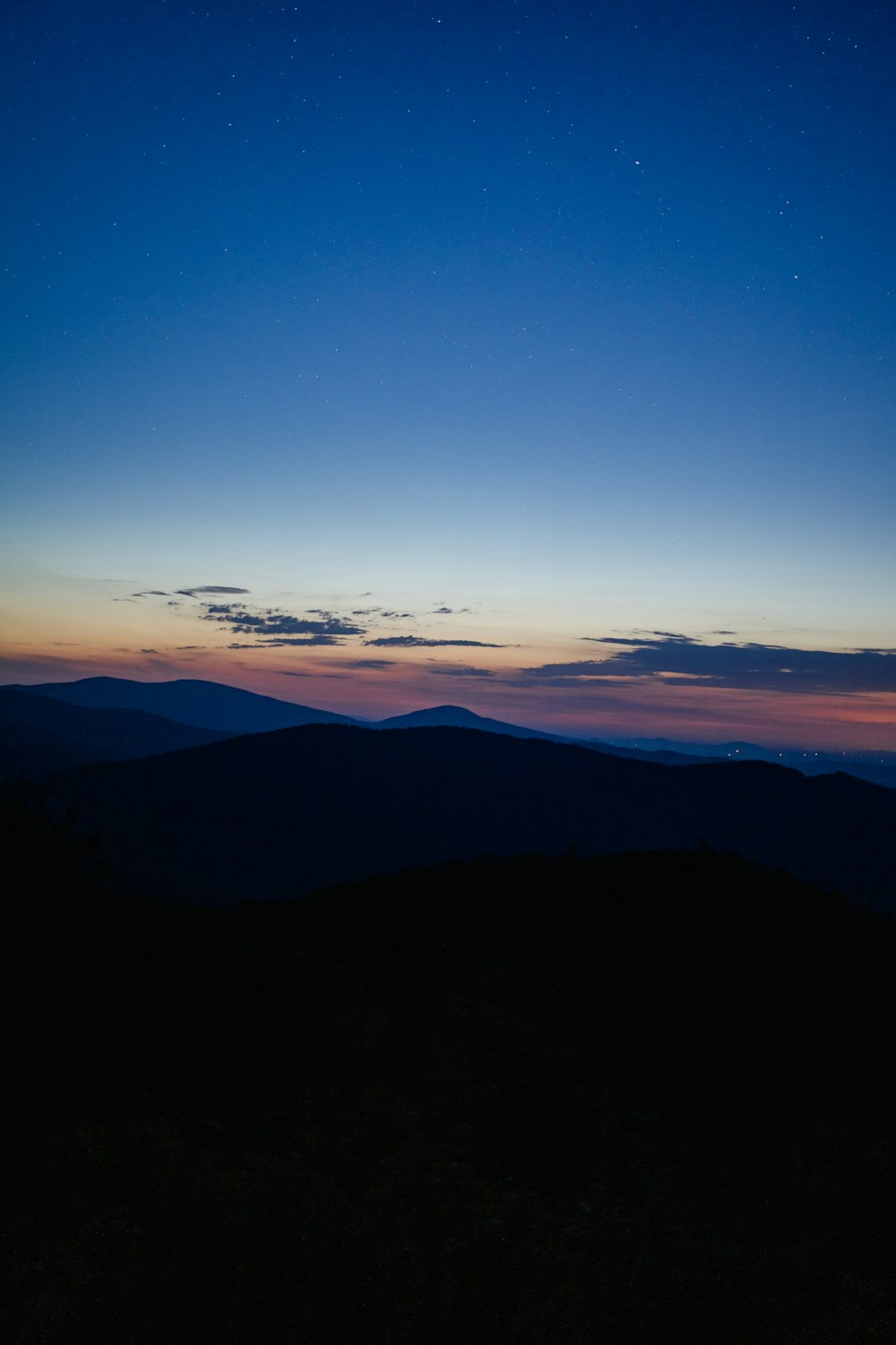 silhouette di montagne sotto il cielo blu durante il tramonto