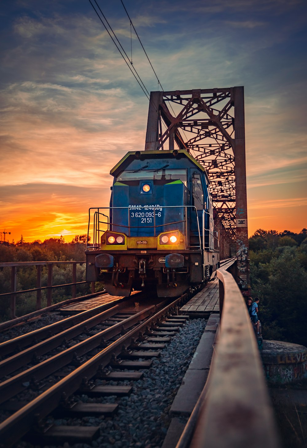 green and brown train on rail tracks during sunset
