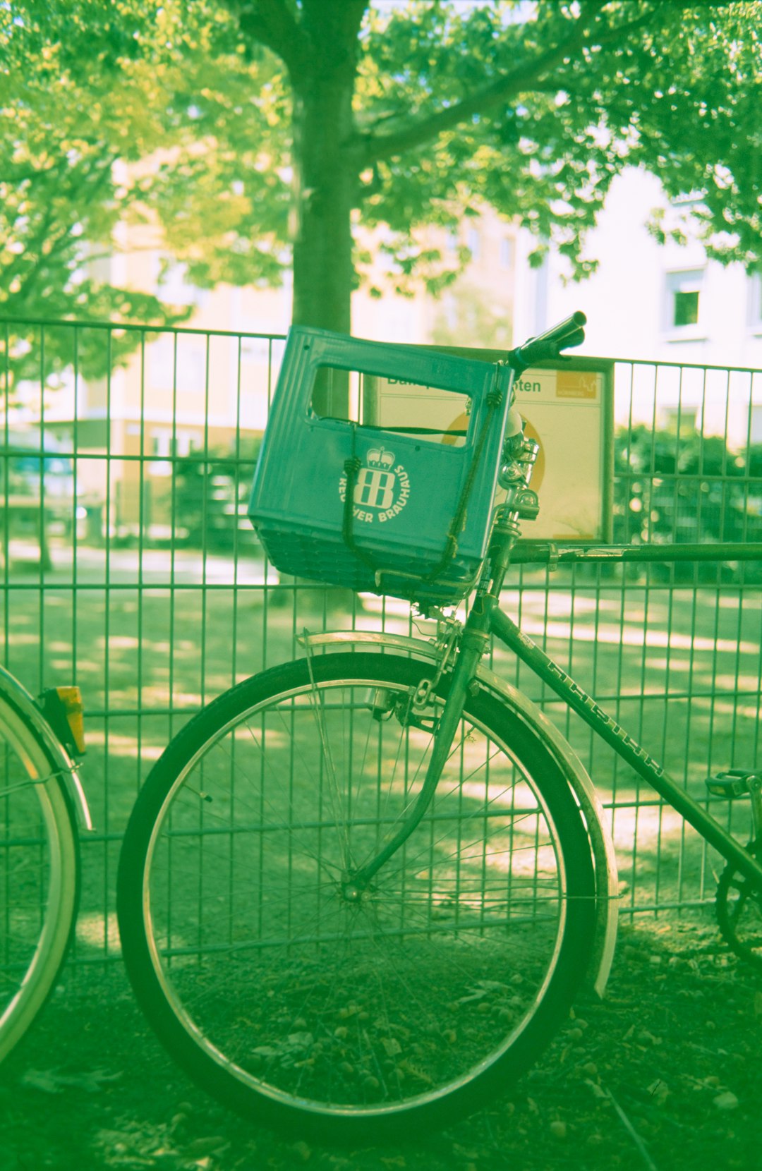 green city bicycle beside green steel fence during daytime