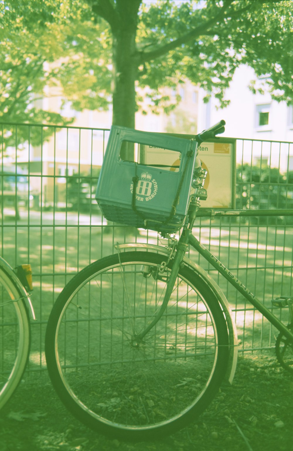 昼間の緑の鉄柵の横の緑のシティ自転車