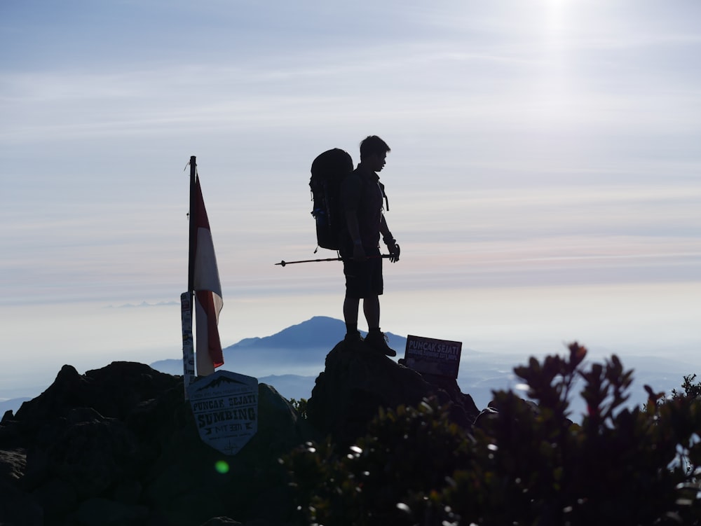 uomo e donna che si baciano sulla cima della montagna durante il tramonto