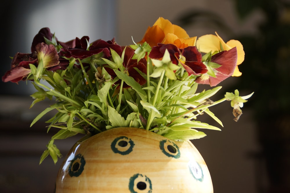 yellow and red flowers in white and brown ceramic vase