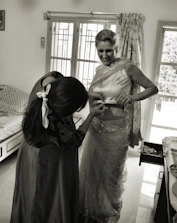 Smiling customer service representative assisting a client with saree selection over the phone.
