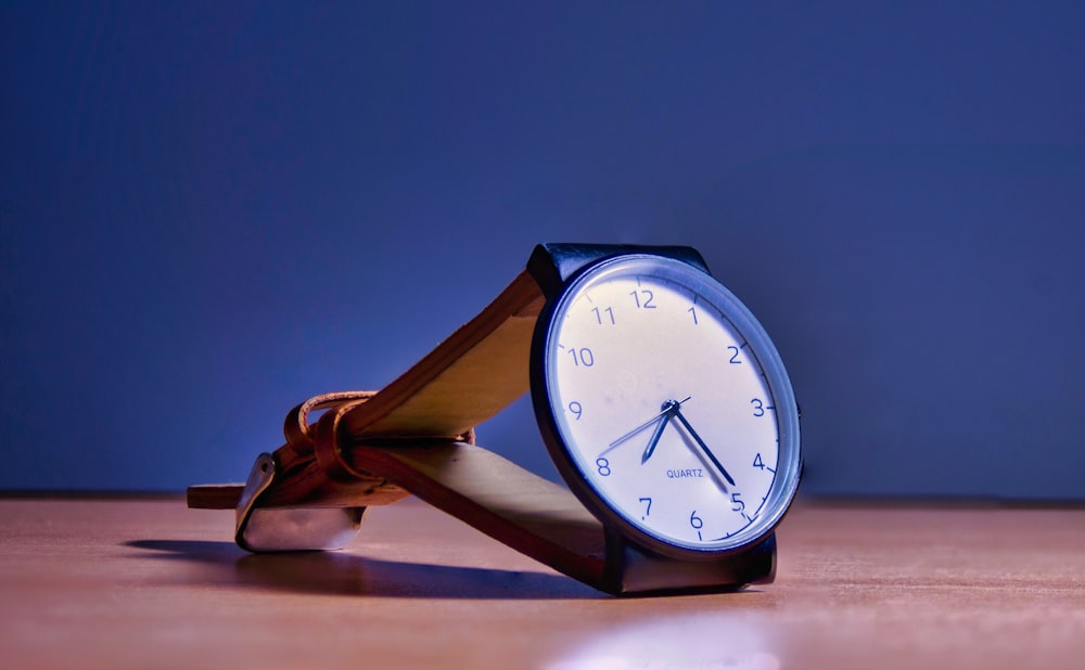 blue and white analog alarm clock at 10 10