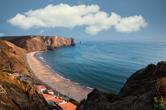 people on beach during daytime in Arrifana Portugal