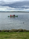 A group of friends laughing while canoeing together.