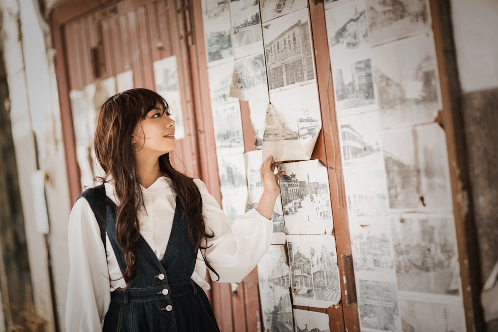 woman in black and white school uniform standing beside glass window