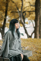 A thoughtful interviewee reflecting during a quiet moment in a park, with autumn leaves around.