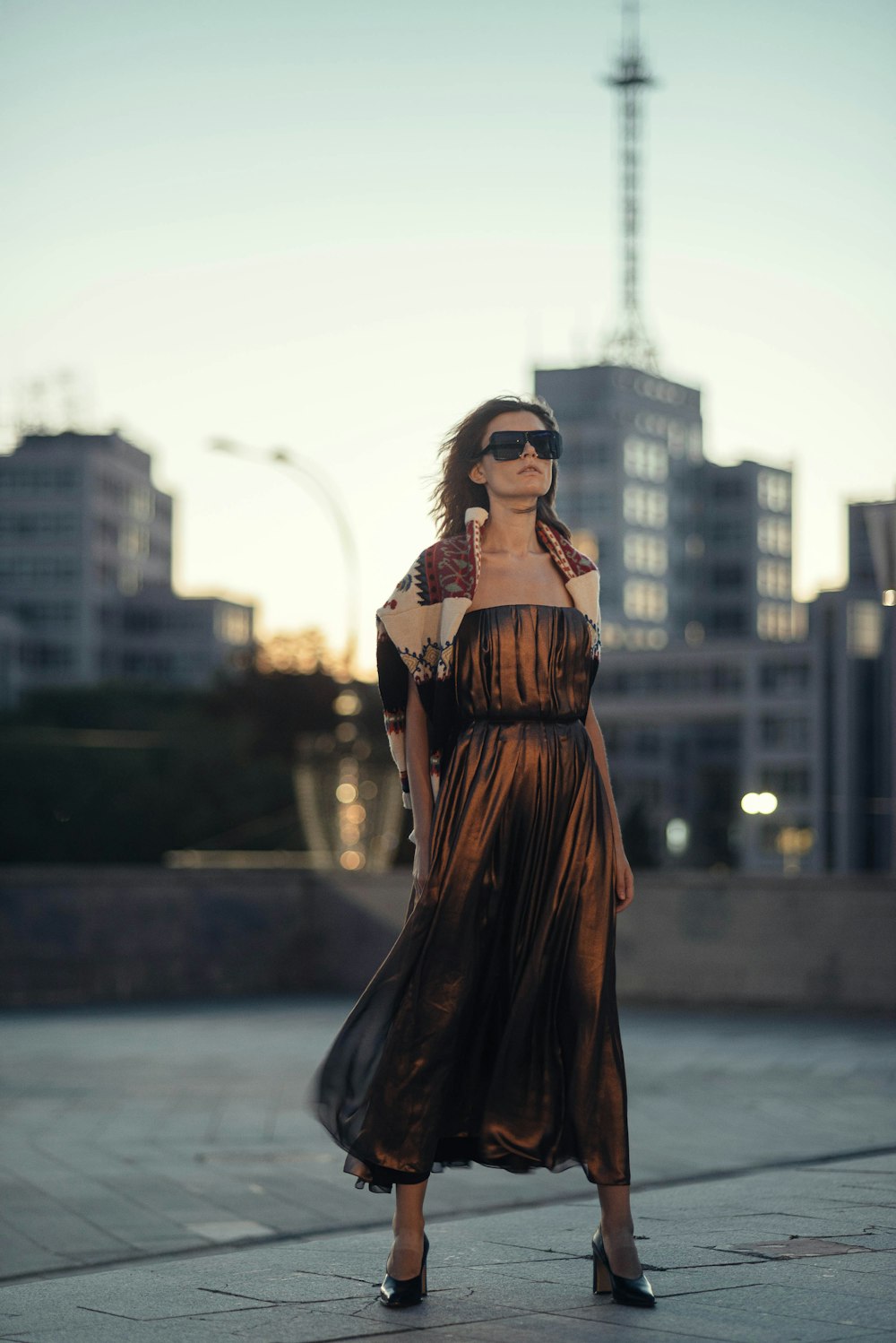 woman in brown dress standing near body of water during daytime