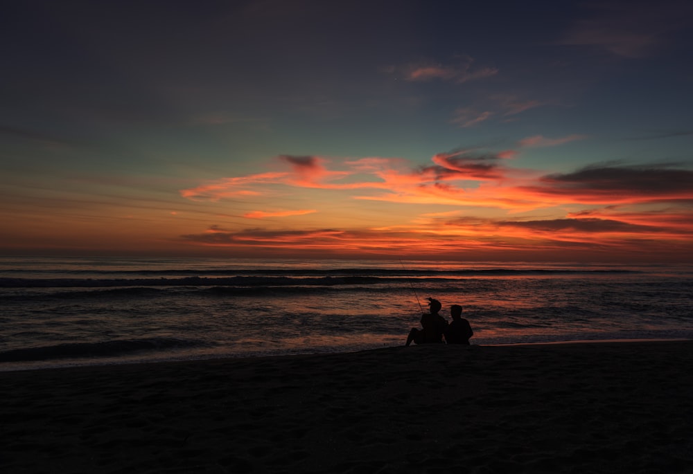 silhouette of people on beach during sunset