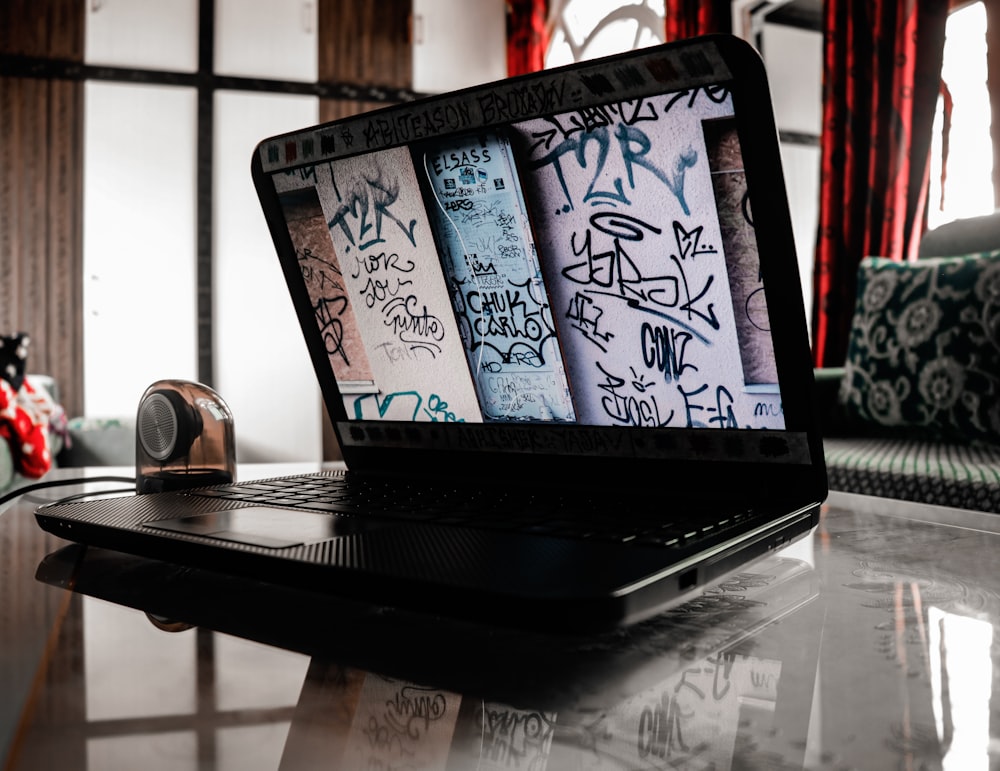 black laptop computer on brown wooden table