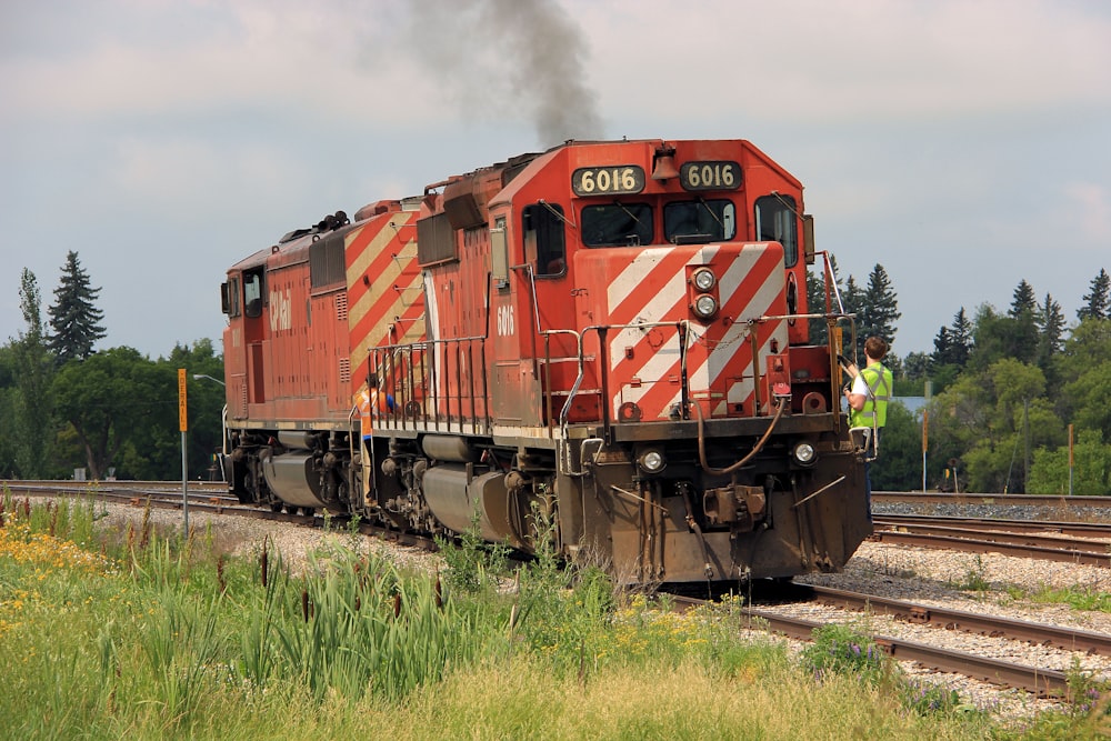 red green and yellow train on rail tracks during daytime