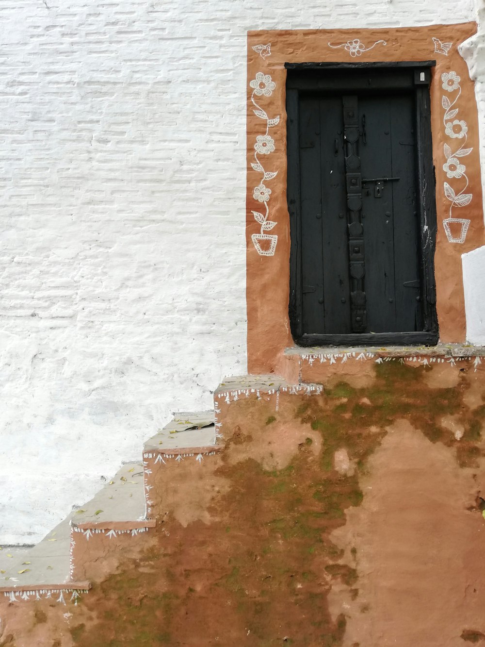 Puerta de madera negra sobre edificio de hormigón marrón